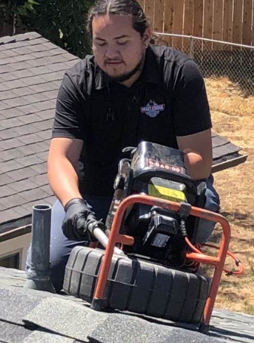 Plumber doing a camera inspection on a roof.