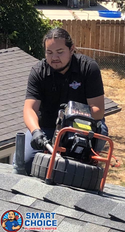 Plumber doing a camera inspection on a roof.